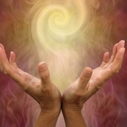 a pair of hands holding a swirling ball of light - an aura