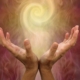 a pair of hands holding a swirling ball of light - an aura