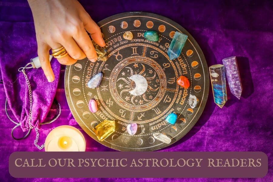 A psychic astrology readers hand on an astrological chart