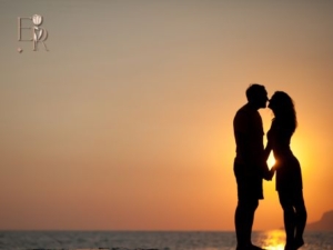 A silhouette of a couple kissing in the sunset whilst stood on the beach