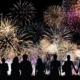 Silhouette of a group of people watching fireworks.