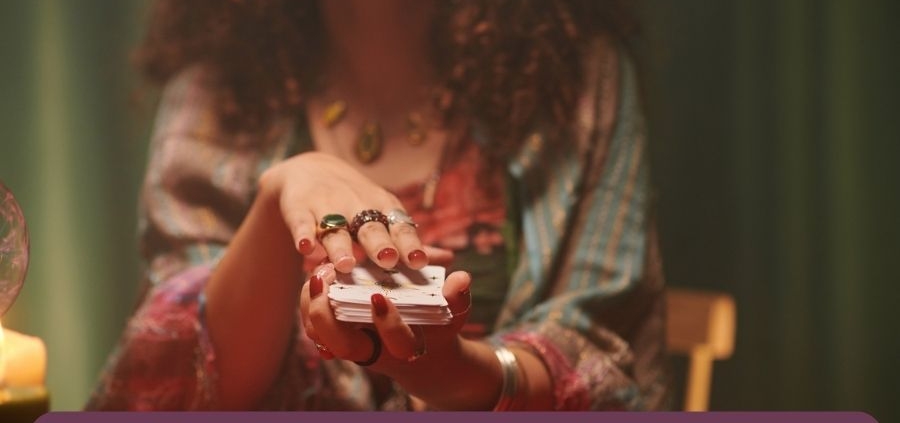 A psychic line reader holding tarot cards banner
