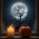 A candle lit windowsill and a pumpkin with a silhouette of a tree and a full moon